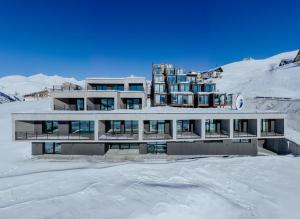 budynek na szczycie pokrytej śniegiem góry w obiekcie Quadrum Hotel w mieście Gudauri