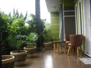 a balcony with plants and a table and chairs at Kartika Guest House Cianjur in Tjiandjur