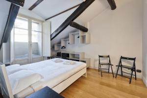 a bedroom with a large bed and two chairs at Stylish Apartment in the heart of Torino in Turin