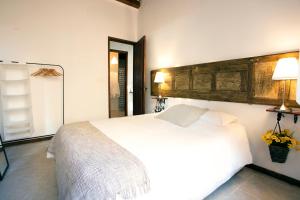 マラガにあるGramaの白いベッド1台(木製ヘッドボード付)が備わるベッドルーム1室が備わります。