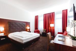 a hotel room with a bed and a desk at Hotel Allegro Wien in Vienna