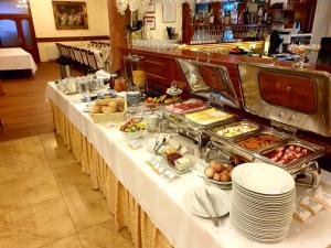a buffet table with food on it in a restaurant at Hotel Alfa in Giraltovce