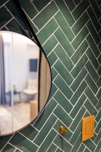 a green tiled wall with a mirror in a room at Old Port Hotel in Limassol