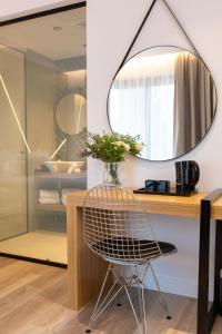 a mirror hangs above a vanity with a chair at Old Port Hotel in Limassol