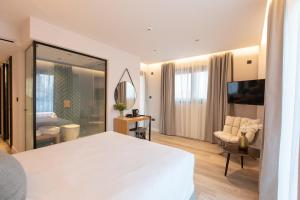 a bedroom with a large white bed and a living room at Old Port Hotel in Limassol