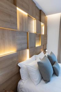 a bedroom with a bed with white sheets and blue pillows at Old Port Hotel in Limassol