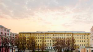 モスクワにあるKvartiraSvobodna - Apartments Park Gorkyの目の前に木々が植えられた大きな黄色の建物
