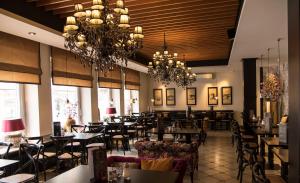 un restaurant avec des tables et des chaises et un lustre dans l'établissement Hotel Zum Goldenen Mann, à Rastatt