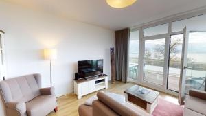 a living room with a couch and a television at Südkap E-04 in Pelzerhaken