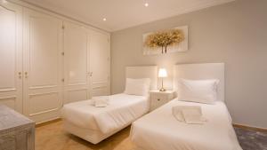 a bedroom with two beds with white sheets at Joanne in Vale do Lobo +6 photos