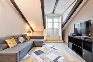 a living room with a couch and a flat screen tv at Stylish Apartment in the heart of Torino in Turin