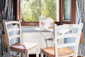 uma mesa e duas cadeiras em frente a uma janela em La Locanda di Borghetto em La Giustiniana