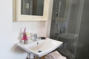 y baño blanco con lavabo y ducha. en La Locanda di Borghetto, en La Giustiniana