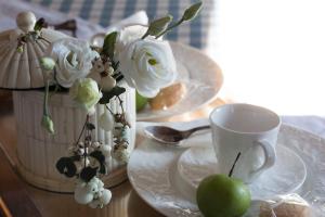 una mesa con platos y una taza y una manzana verde en La Locanda di Borghetto, en La Giustiniana