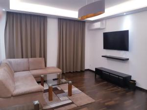 a living room with a couch and a flat screen tv at Royal Boardinghouse GmbH - Munich in Munich