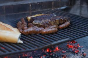 un grupo de salchichas y carne en una parrilla en Cabañas del Arroyo Calafate (CRyPPSC) en El Calafate