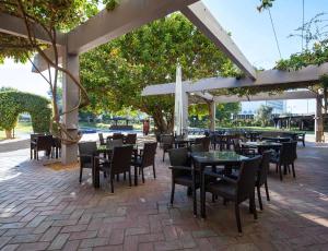 a patio area with tables, chairs and umbrellas at Dom Pedro Vilamoura in Vilamoura