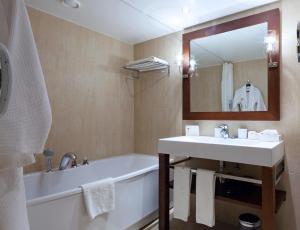 a bathroom with a sink, mirror and bath tub at Dom Pedro Vilamoura in Vilamoura