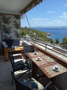 einen Balkon mit einem Tisch und Stühlen sowie Meerblick in der Unterkunft Atlas Apartment with Private Beach and SeaView in Loutraki