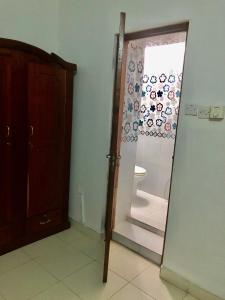 a bathroom with a mirror and a door to a toilet at Michenzani Flat in Zanzibar City