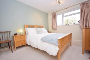 a bedroom with a large bed and a window at Orchard Mews , Barnham in Barnham