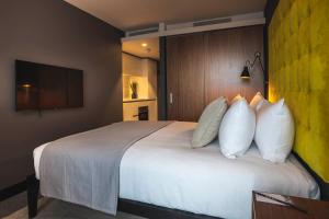 a hotel room with a large bed with white pillows at The Gate London City in London