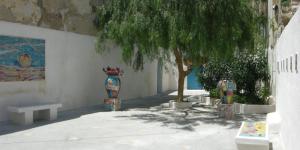 un mur avec deux vases, un arbre et un banc dans l'établissement Al Madinah, à Mazara del Vallo