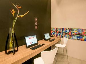 a desk with a laptop computer and two chairs at Hotel Ibis Cali Granada in Cali