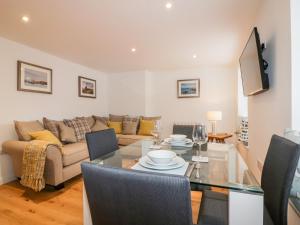 a living room with a table and a couch at Midships in St Austell
