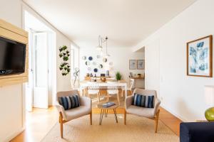 a white living room with a table and chairs at ALTIDO Chiado Self Check-In 2-BR Flat with Parking in Lisbon