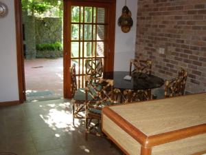 comedor con mesa, sillas y pared de ladrillo en Calandria, en Cuchilla Alta