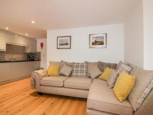 a living room with a couch and a kitchen at Midships in St Austell