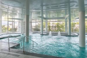 a swimming pool with water fountains in a building at Hôtel Les Corallines - Thalasso & Resort in La Grande Motte