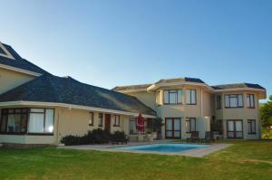 a house with a swimming pool in the yard at Sandbaai Country House in Hermanus