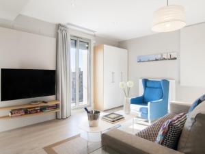 sala de estar con TV, sofá y silla en Kronos on the Beach Attic Suite en Barcelona