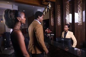 a group of people standing around a counter in a bar at New Day Hotel in Addis Ababa