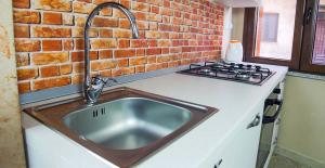 a kitchen with a sink and a brick wall at Alba Sarda Residence in Iglesias