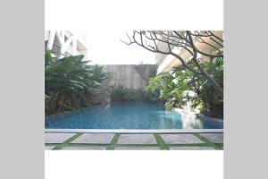 a swimming pool in the middle of a garden at Exotic Chamber in Malang