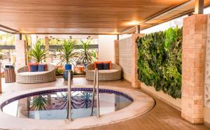 a hot tub in the middle of a room with plants at Hotel Morada do Sol in Caldas Novas