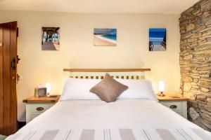 圣提斯The White Cottage B&B的一间卧室配有一张床,墙上挂着一些绘画作品