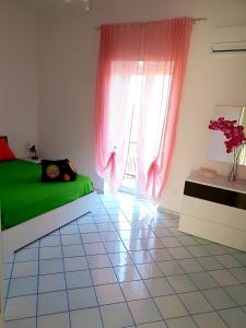 a bedroom with a green bed and a window at casa vacanza cilento PARDALIS in Agropoli