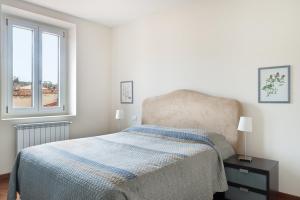 ein weißes Schlafzimmer mit einem Bett und einem Fenster in der Unterkunft Anguillara in the Heart of Florence in Florenz