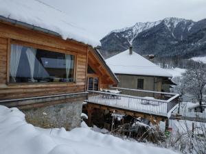 Cette cabane en rondins dispose d'un balcon dans la neige. dans l'établissement Le ptit Tavalan, à Seythenex