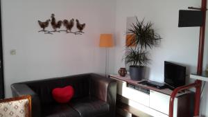 sala de estar con sofá de cuero marrón y TV en 't Hokling, en Boazum