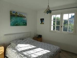 um quarto com uma cama e duas janelas em Villa Alessia em Antibes