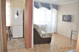 Habitación con silla frente a una ventana en 1 комнатные апартаменты на Абая 134, en Kokshetau