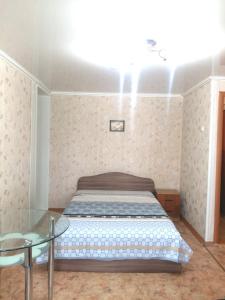 a bedroom with a bed and a glass table at 1 комнатные апартаменты на Абая 134 in Kokshetau