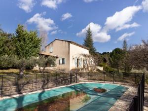 a house with a swimming pool in front of a fence at Serena Villa in Saignon with Private Swimming Pool in Saignon