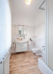 a white bathroom with a sink and a toilet at Gasthof Runge in Barenburg