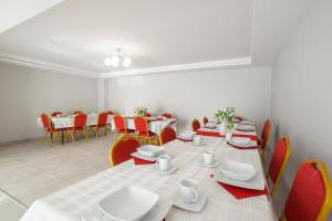a dining room with a long table and red chairs at Górska Chata u Kota in Huta Szklana